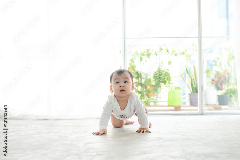 漂亮的小女婴在家里的地板上爬行