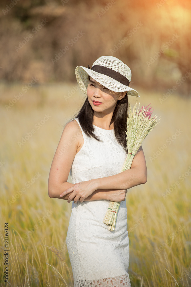 迷人的年轻女子在夏日日落的灯光下享受户外时光，特写肖像