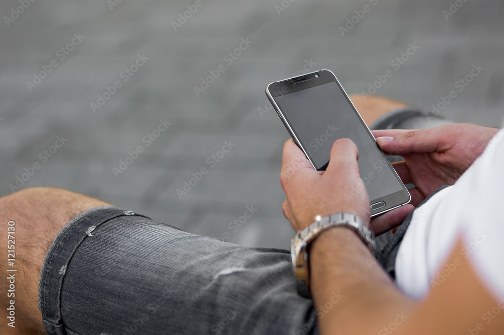 Close up of a man using mobile smart phone outdoor