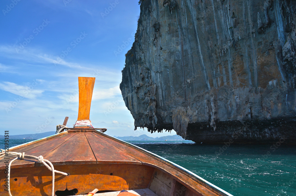 Fisherman travel boat meet ocean cliff with summer blue sky in Thailand