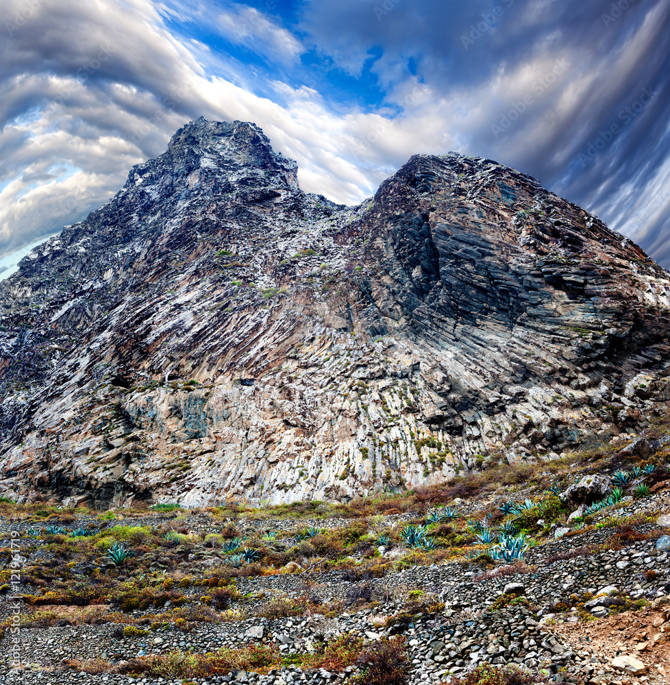 Pico de montaña.Formación tectonica.Geologia y naturaleza.Paisaje rocoso acantilado y vegetación