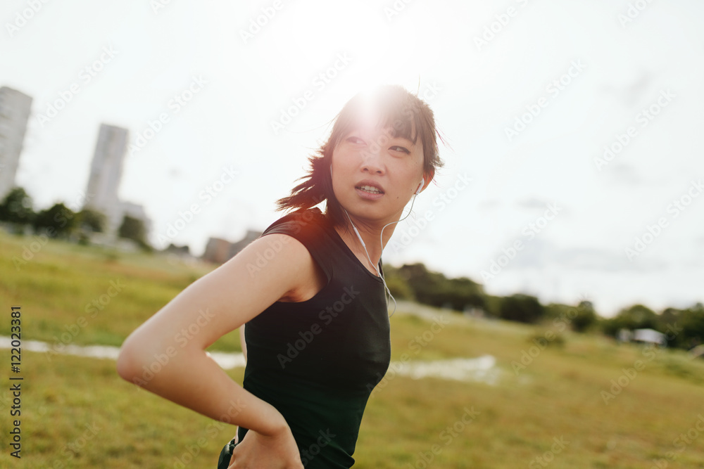 Fitness female on field glancing back