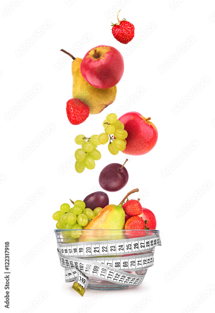 Fruit falling in a glass bowl on white