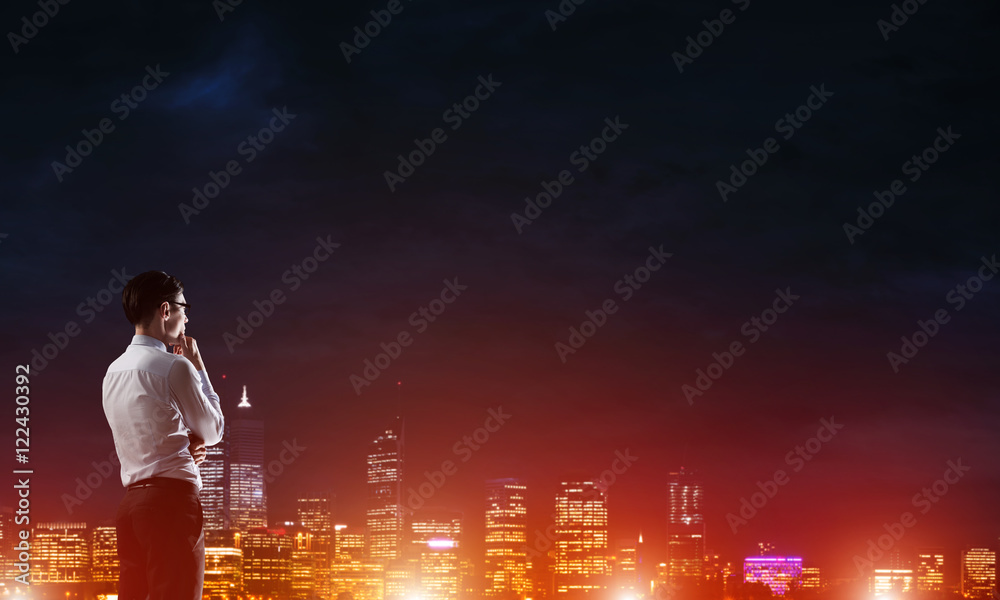 Businessman viewing night glowing city