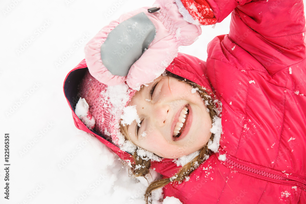 Playful girl with braids playing in the first snow