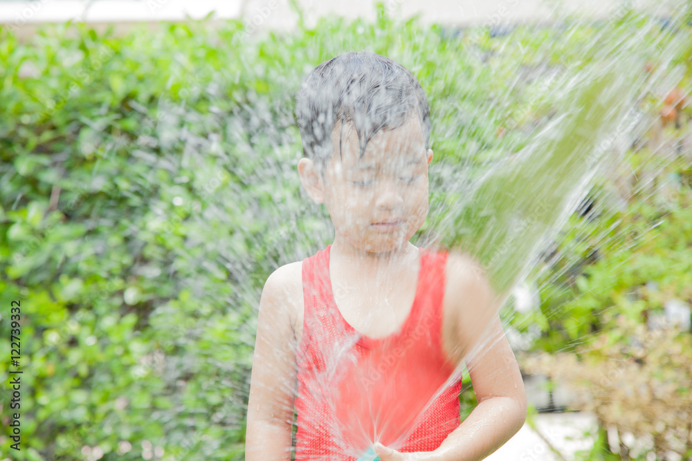 Little boy playing water splash