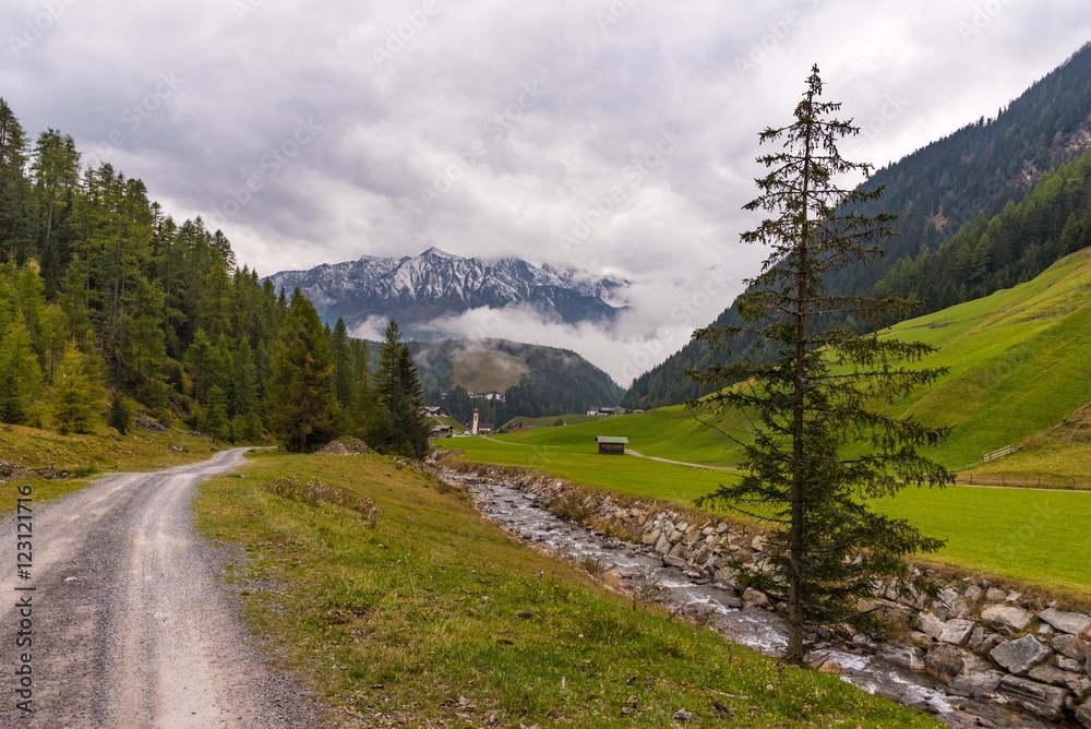 Weg und Bach mit Blick auf Niederthai Wolken