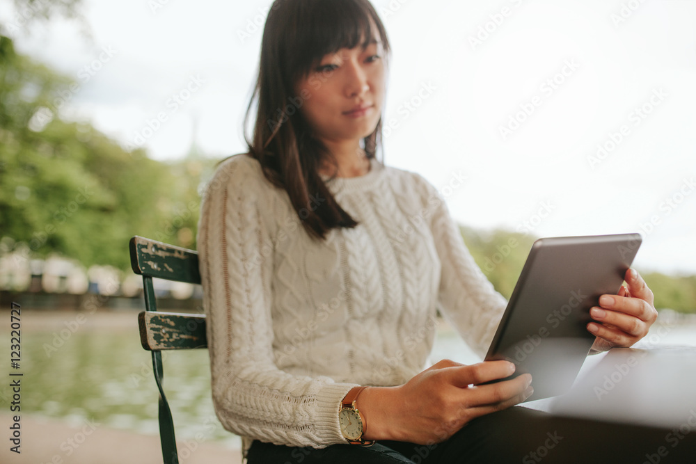 年轻女性在她的数字平板电脑上阅读电子书