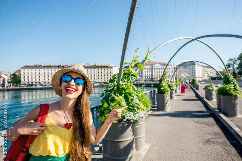 年轻的女性旅行者站在瑞士日内瓦市中心的人行天桥上。