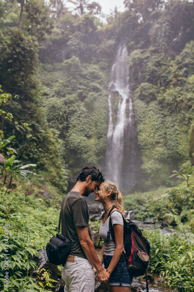 Affectionate young couple standing together in forest