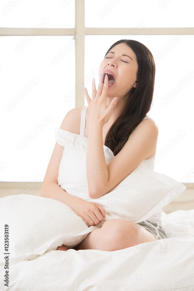 beautiful asian woman yawn and holding pillow in morning