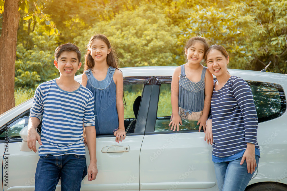 Happy Asian family with mini van are smiling and preparing for travel on summer