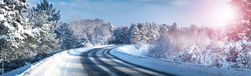 汽车在被雪覆盖的冬季道路上行驶