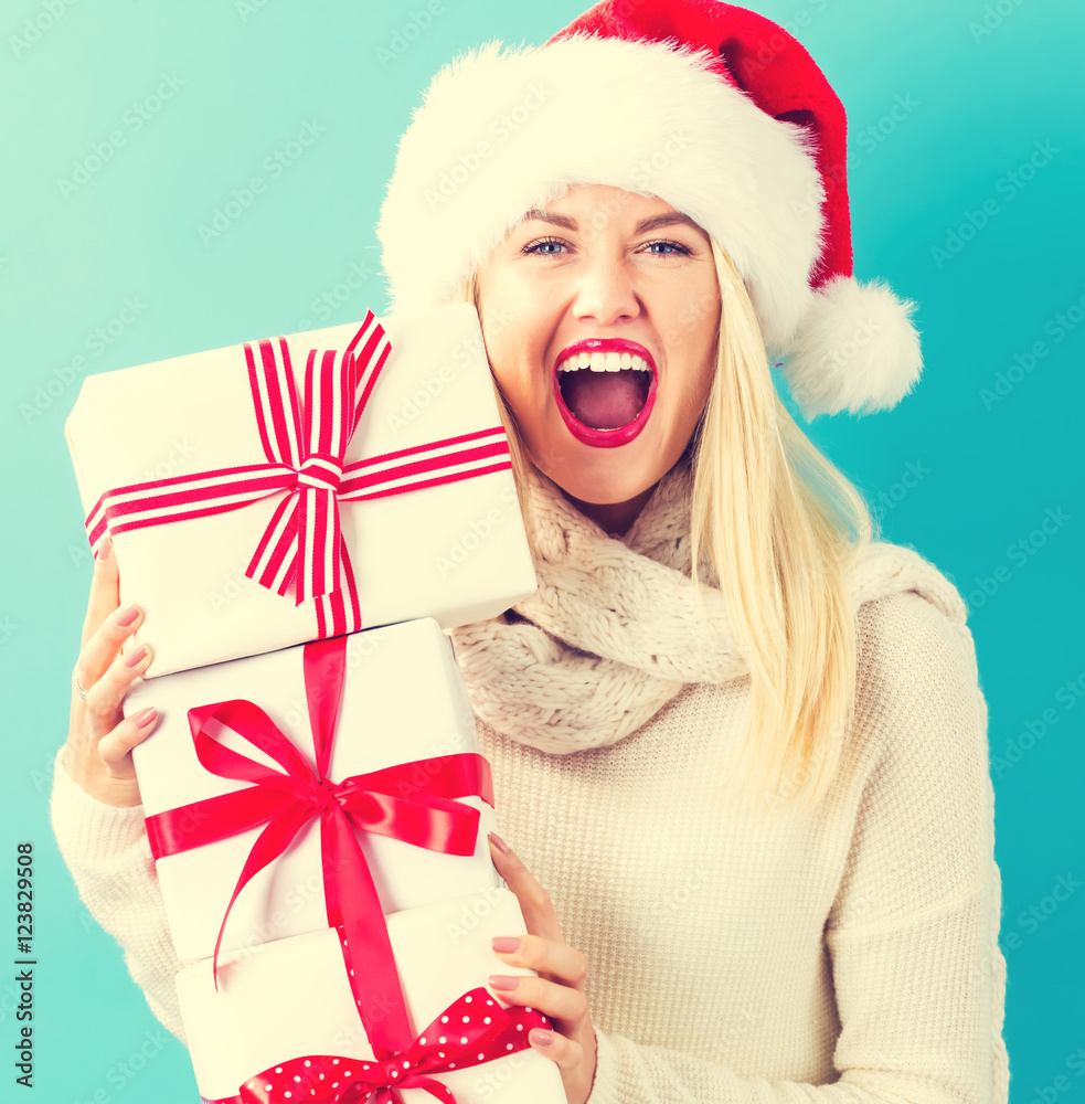 Woman with santa hat holding gift boxes