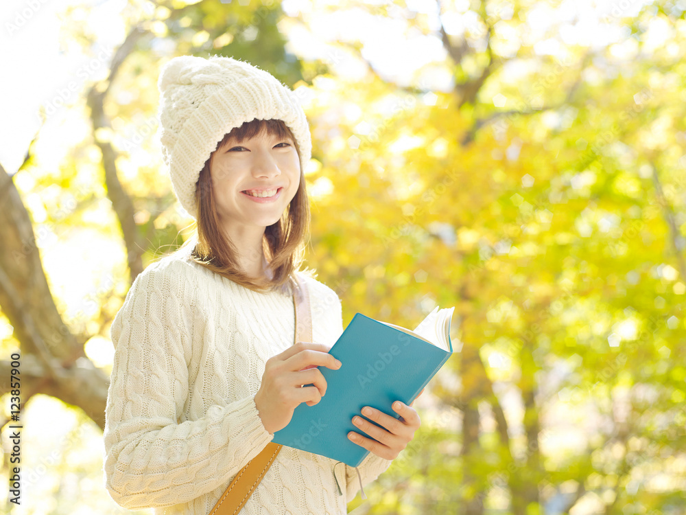 紅葉の中で読書する女性