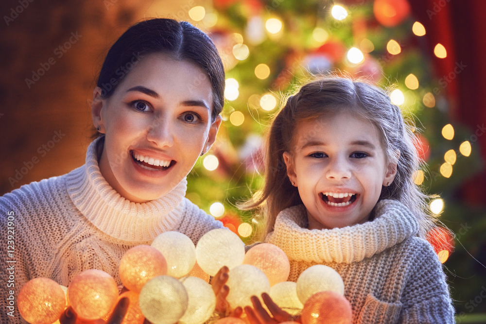 Mom and daughter decorate the Christmas tree.