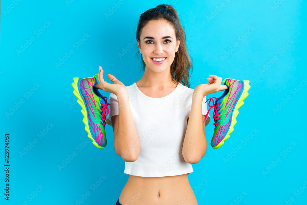 Happy young woman holding shoes