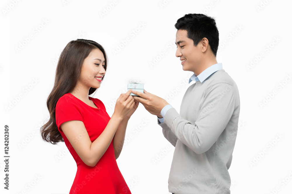 Man makes present to his lovely sweetheart. Young man giving a g