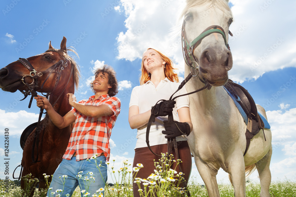 Happy couple riding their horses at countryside