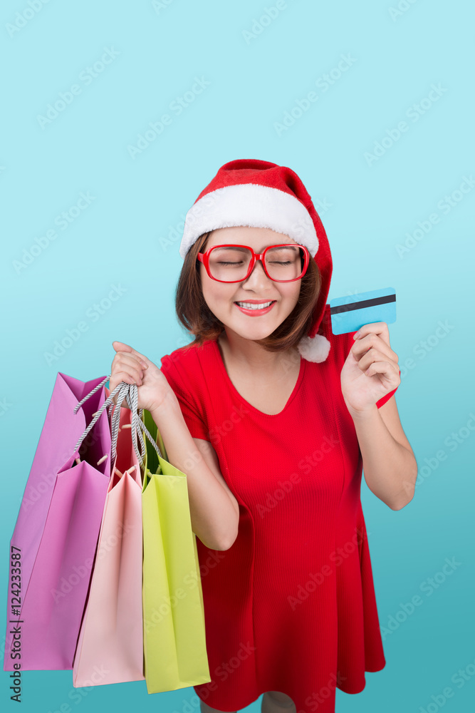 Santa asian woman holding shopping bags and credit card against