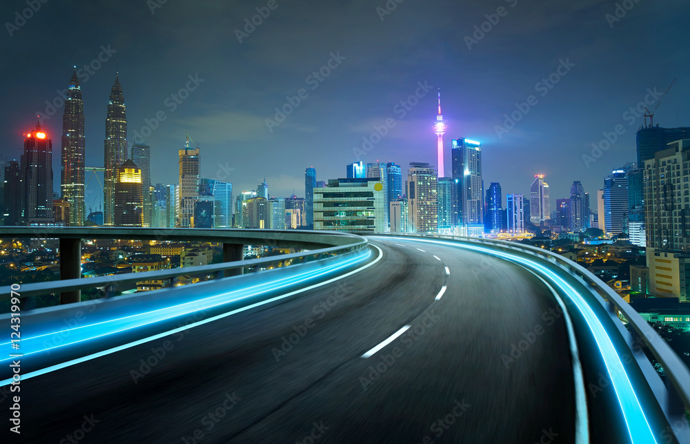 Blue neon light highway overpass motion blur with city  skyline background , night scene .