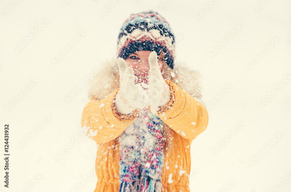 戴着手套玩雪地的年轻女子户外寒假旅行生活方式