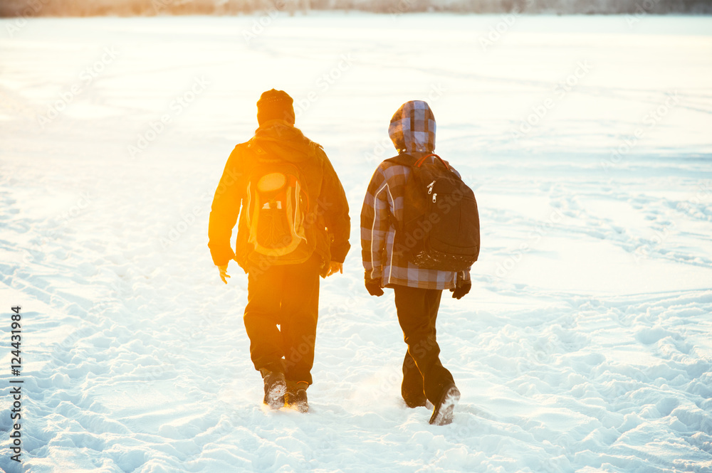 孩子朋友背着学校背包散步冬季下雪天气