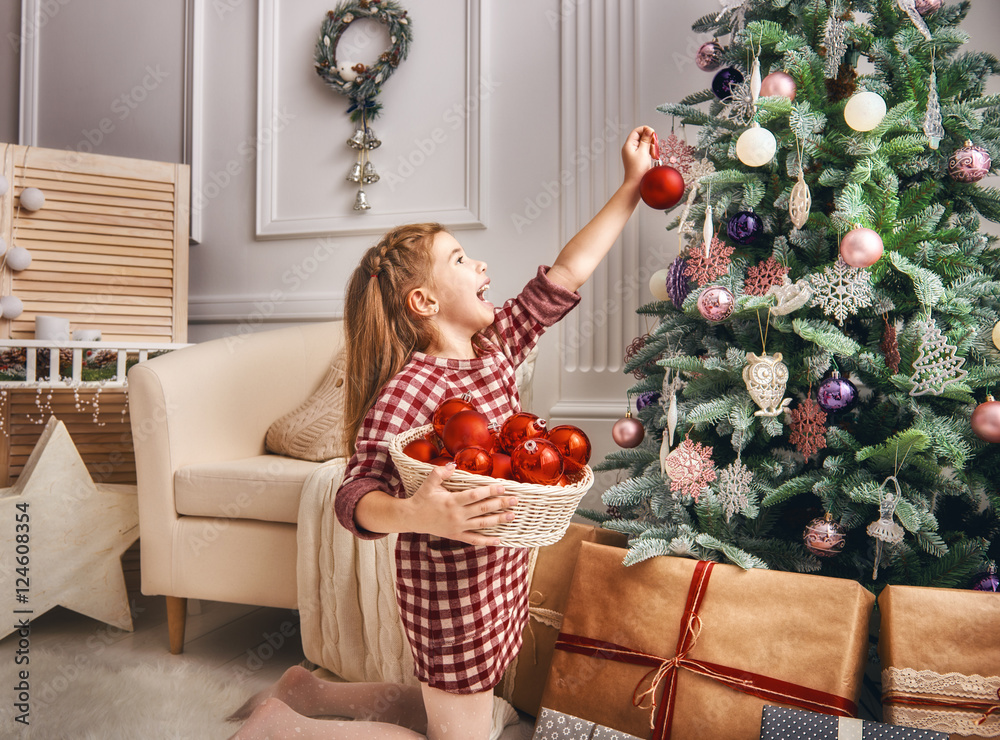 girl is decorating the Christmas tree