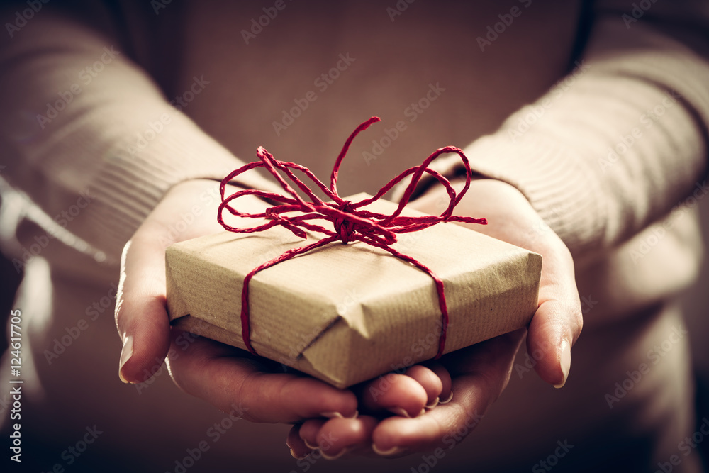 Giving a gift, handmade present wrapped in paper