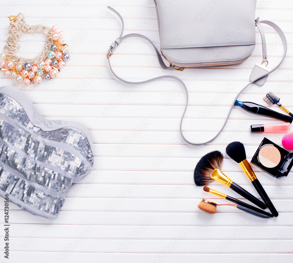 Womans clothing and accessories placed on a wooden background