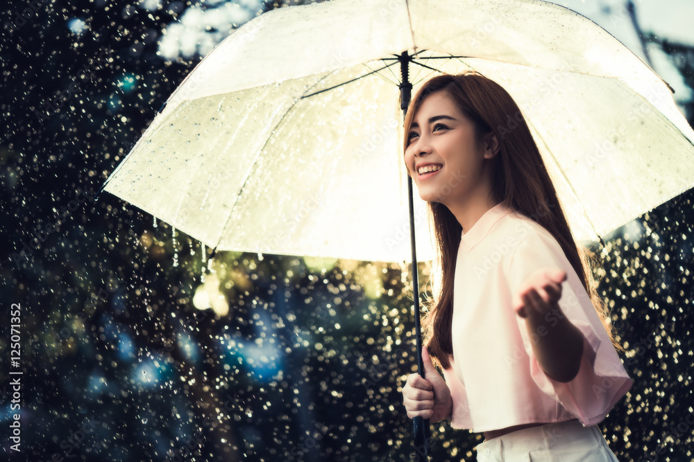 Asian woman waiting for the rain, she had an umbrella.