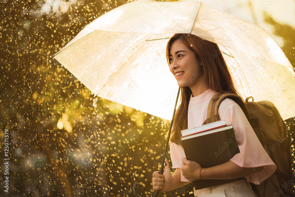 亚洲女人在等雨，她有一把伞。