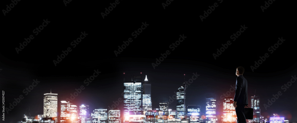 Businessman viewing night glowing city