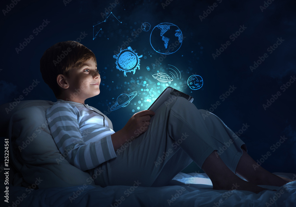 Boy with tablet in his bed