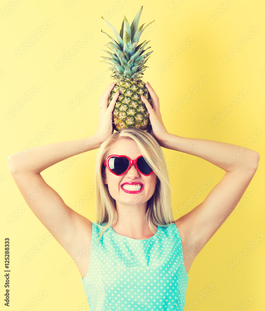 Happy young woman holding a pineapple