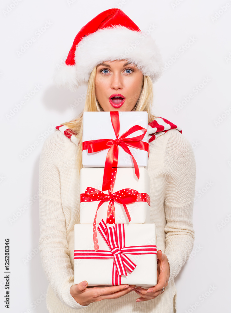 Woman with santa hat holding gift boxes