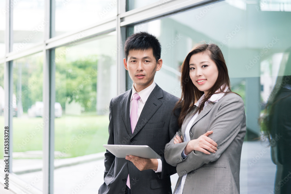 asian beautiful girl and businessman with tablet in modern hall