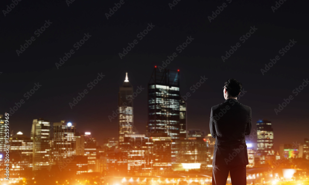 Businessman viewing night glowing city