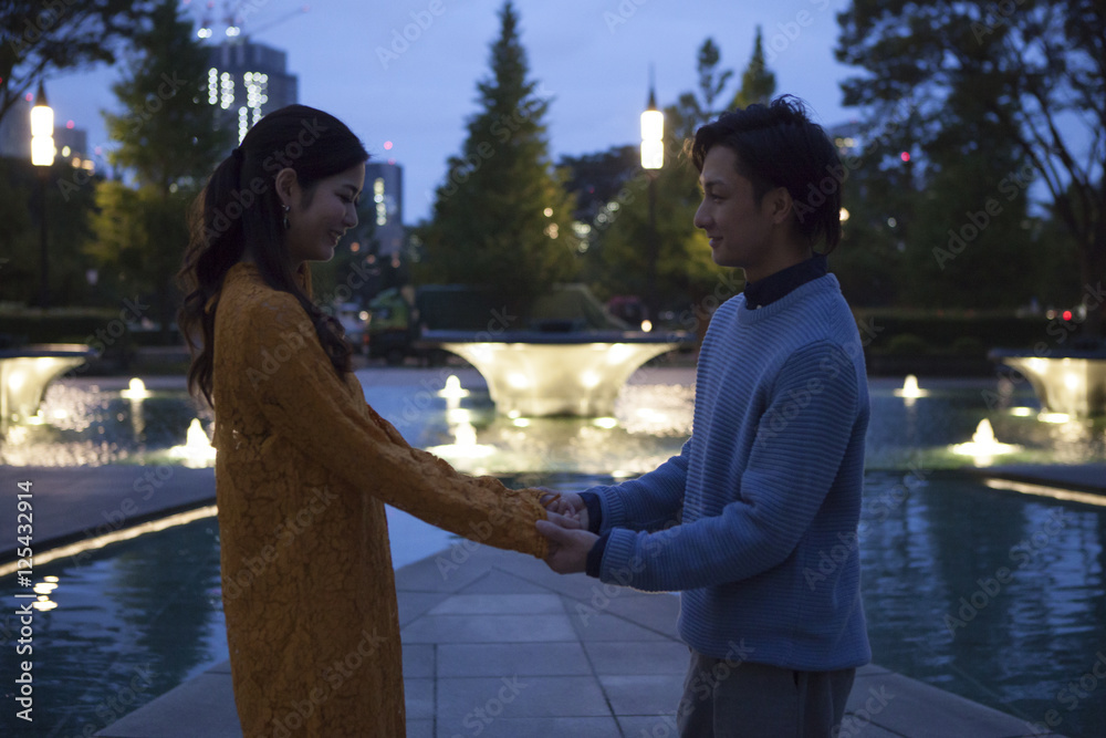 The couple have been dating holding hands in the night of the park