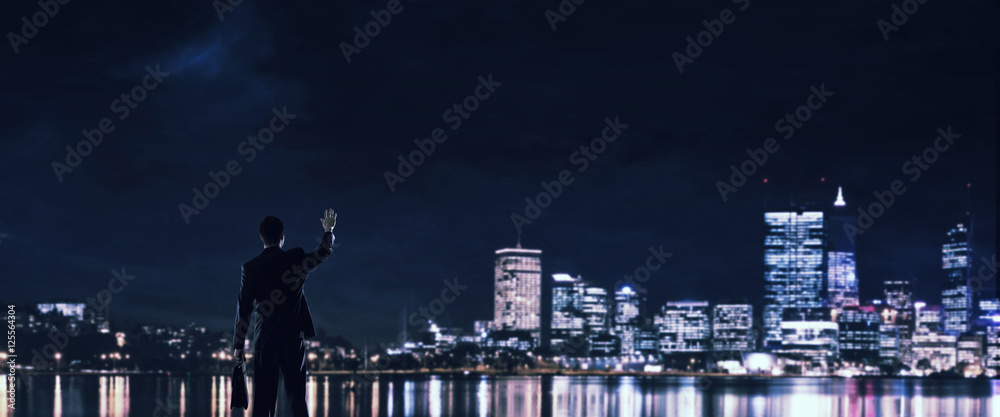 Businessman viewing night glowing city