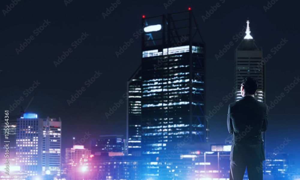 Businessman viewing night glowing city