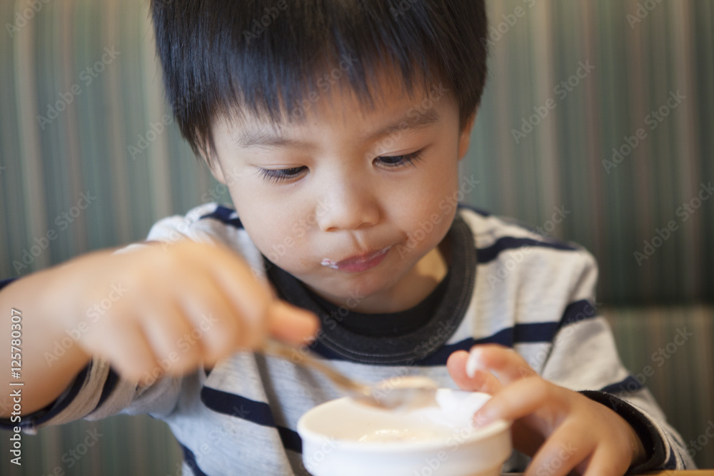 The boy is eating a dessert