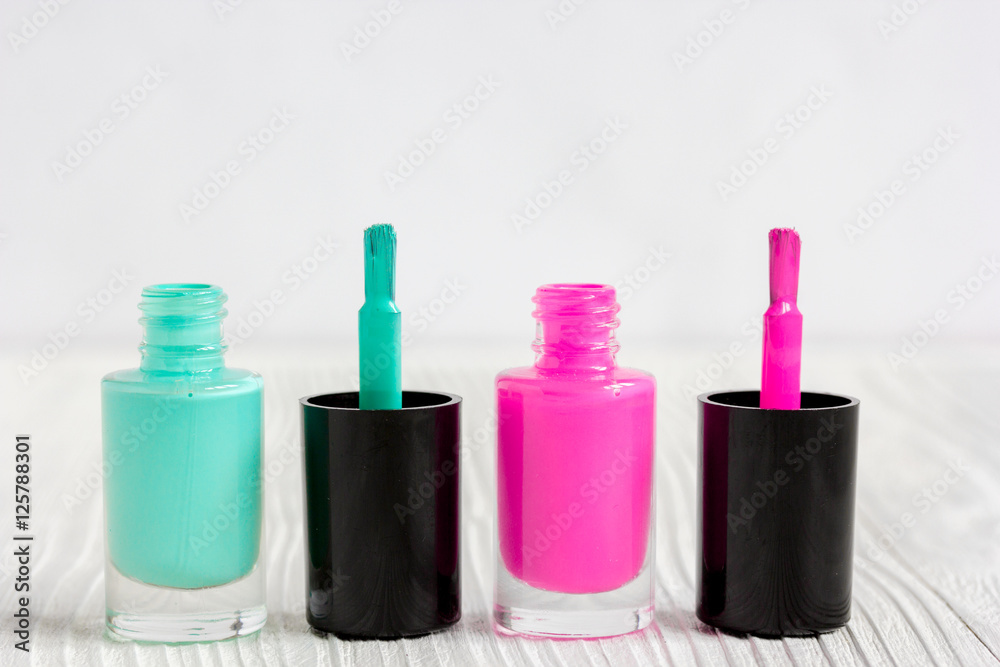 open bottles of nail polish on wooden background