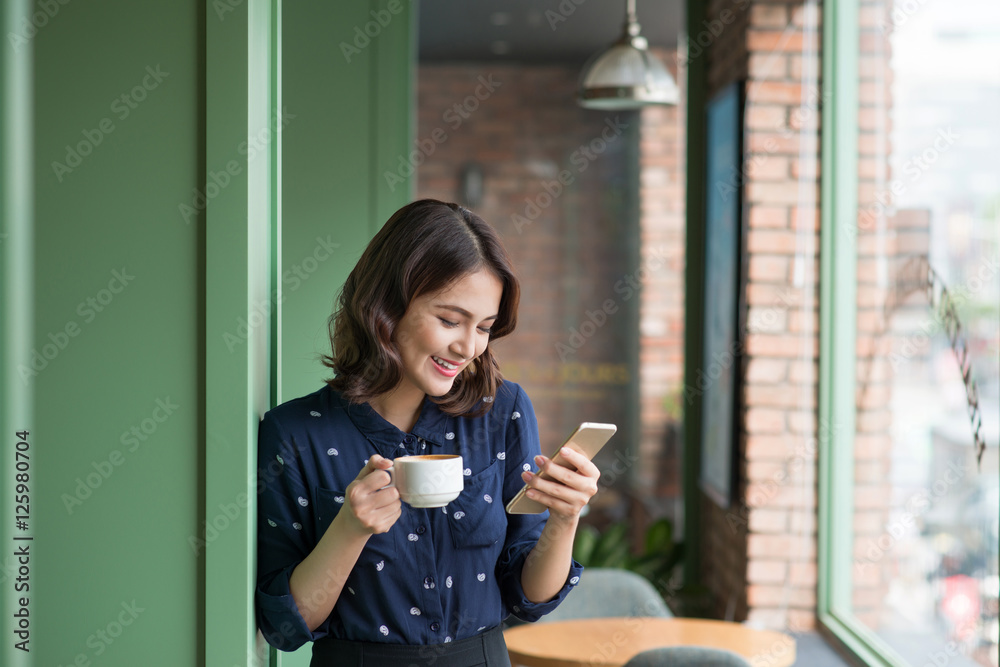 Beautiful cute asian young businesswoman in the cafe, using mobi