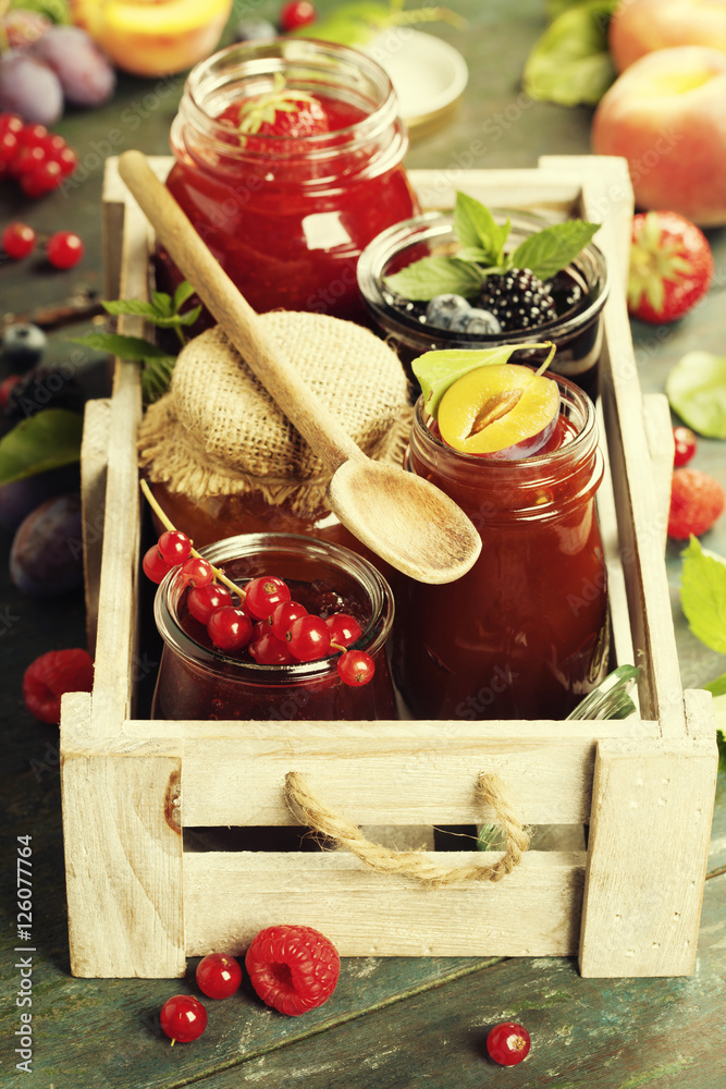 Fruit and berry jam on a wooden background