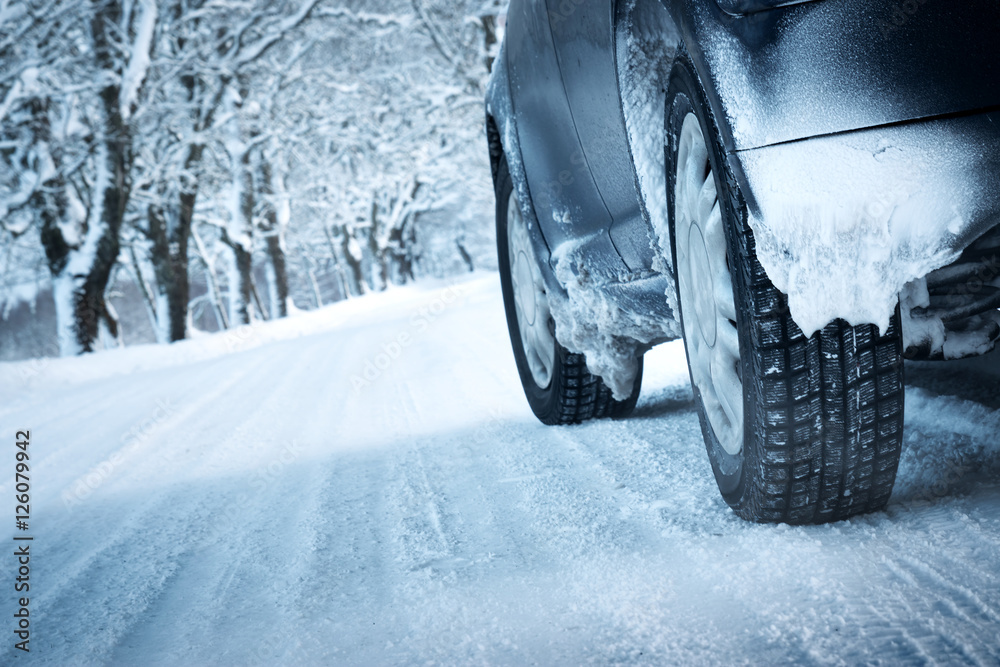 Car tires on winter road covered with snow