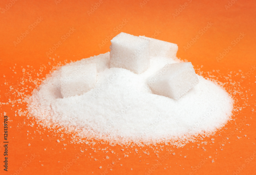 Pile of white sugar isolated on red background