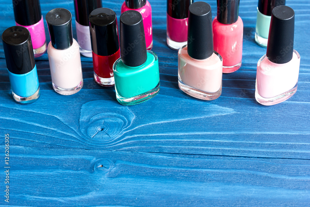 bottles of colored nail polish on wooden background