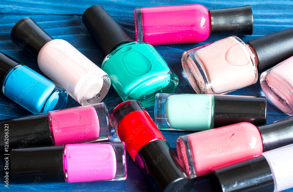 bottles of colored nail polish on wooden background