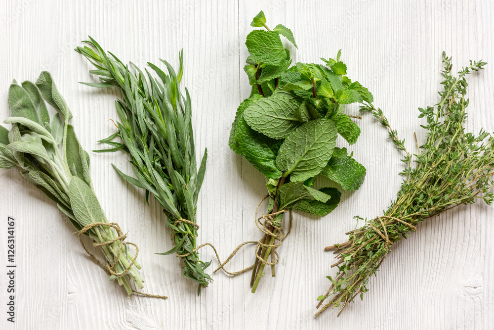 bundles of herbs on wooden background top view